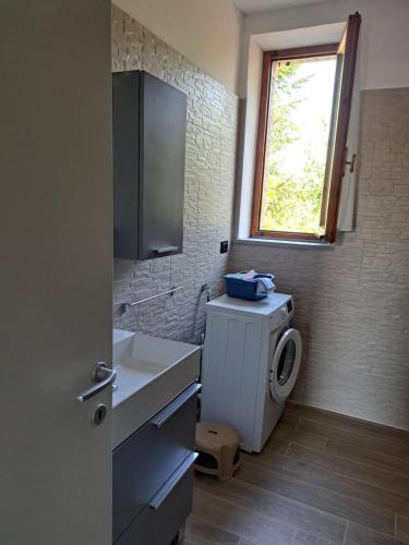 a bathroom with a sink and a washing machine at B&B Le Scintille in San Ginesio