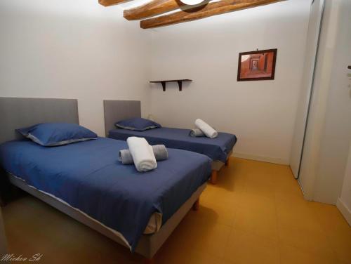 - 2 lits dans une chambre avec des draps et des oreillers bleus dans l'établissement L'Atypique Saumurois, à Saumur