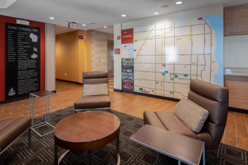 a lobby with chairs and a map on the wall at TownePlace Suites by Marriott Milwaukee Oak Creek in Oak Creek