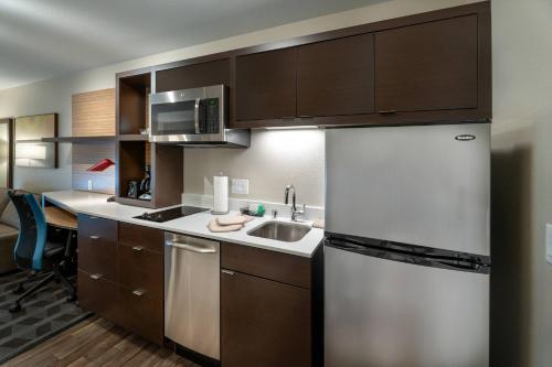 a kitchen with a white refrigerator and a sink at TownePlace Suites by Marriott Milwaukee Oak Creek in Oak Creek