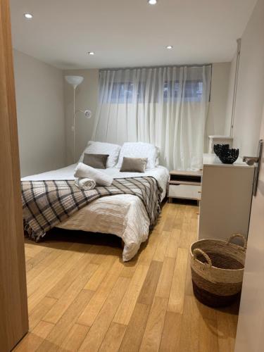 une chambre avec un lit et une grande fenêtre dans l'établissement Osiris, à Argenteuil