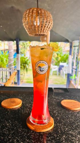 a drink sitting on a table with a slice of orange at Garden Aroma Palolem, Beachside Hostel & Cafe Bar in Palolem