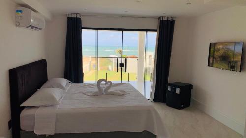 a bedroom with a bed with a swan on it at Pousada Casa Branca in Extremóz