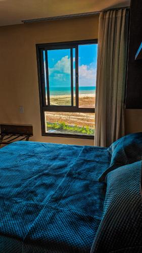 a bedroom with a bed and a window with a view at VG Sun Cumbuco by TP Flats in Cumbuco