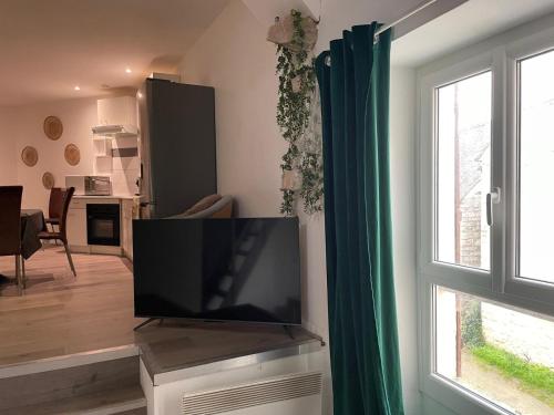 - un salon avec une télévision à écran plat à côté d'une fenêtre dans l'établissement Petit appartement atypique, à Tousson