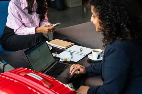 a woman sitting at a desk with a laptop computer at Moxy Utrecht in Utrecht