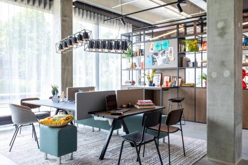 an office with two tables and chairs in a room at Moxy Utrecht in Utrecht