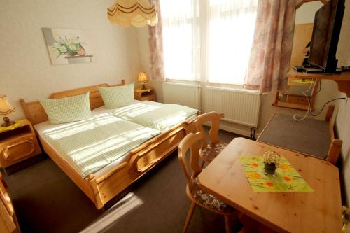 a bedroom with a bed and a table in it at Hotel SchwarzaBurg in Schwarzburg