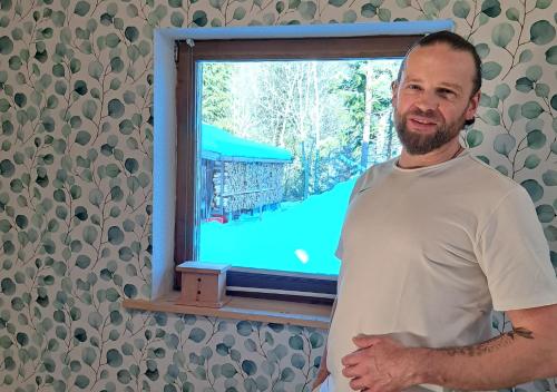 a man standing in front of a window at Naturetouch in Steinberg am Rofan
