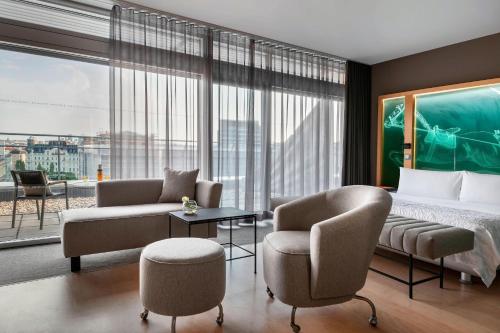 a hotel room with a bed and two chairs at Le Méridien Vienna in Vienna