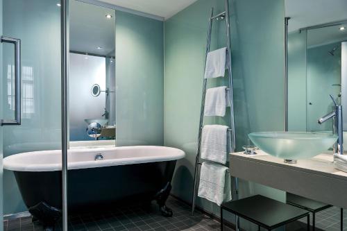 a bathroom with a bath tub and a sink at Le Méridien Vienna in Vienna