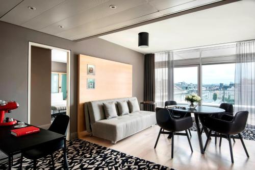 a living room with a couch and a table and chairs at Le Méridien Vienna in Vienna