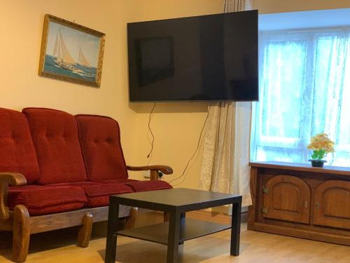 a living room with a red couch and a flat screen tv at 4 Bed Room Sharing House in Phibblestown