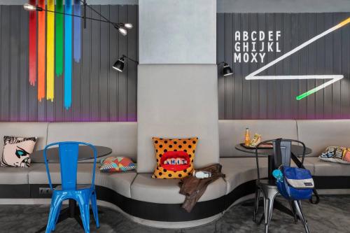 a waiting room with colorful chairs and a table at Moxy Bucharest Old Town in Bucharest