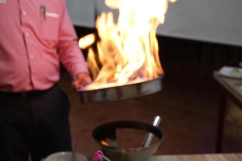 a man standing in front of a fire oven at Plaza Uruapan Hotel  in Uruapan del Progreso
