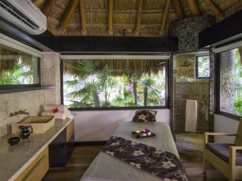 ein Schlafzimmer mit einem Bett und einem Waschbecken in einem Zimmer in der Unterkunft 2BD Del Palmar Cancun Oceanview Pool & Resort in Cancún