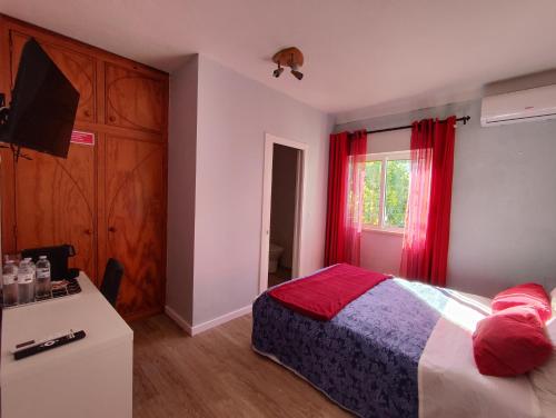 a bedroom with a bed and a window with red curtains at Casa Maria in Loures