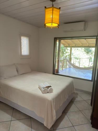 a bedroom with a bed and a large window at Lagoa Hospedaria in Imbituba