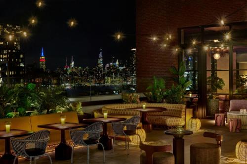 a restaurant with a view of the city at night at Moxy Brooklyn Williamsburg in Brooklyn