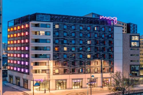 a building with a neon sign on top of it at Moxy London Stratford in London