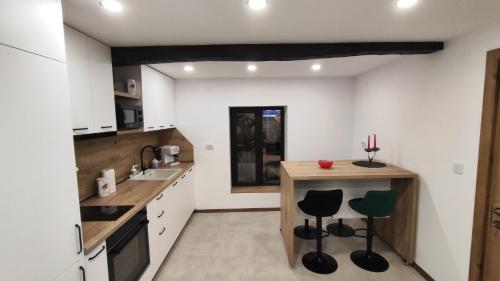 a kitchen with a counter and stools in it at Вивиан - модерна вила за гости in Reselets