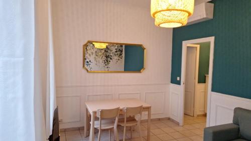 une salle à manger avec une table, des chaises et un miroir dans l'établissement Appartement Toulon, à Toulon