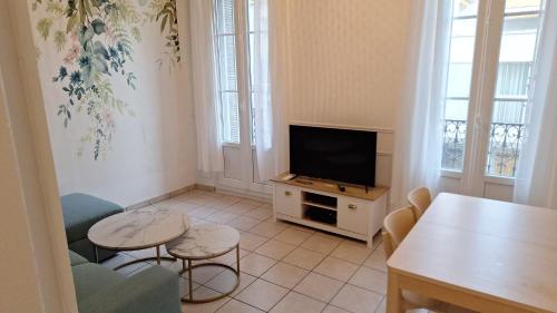 un salon avec une télévision et une table dans l'établissement Appartement Toulon, à Toulon