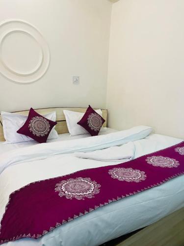 a bedroom with two beds with purple and white pillows at The Hidden Cove in Bhīm Tāl