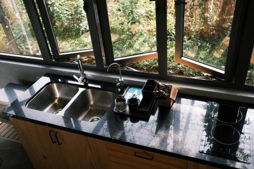 a sink in a kitchen with a window at MAI HOTAY Lakeside Highland Retreat Homestay in Ðức Lập