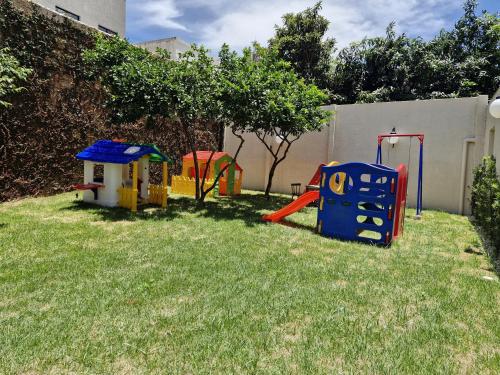 a yard with some playground equipment in the grass at San Rafael Comfort Class Hotel in Foz do Iguaçu