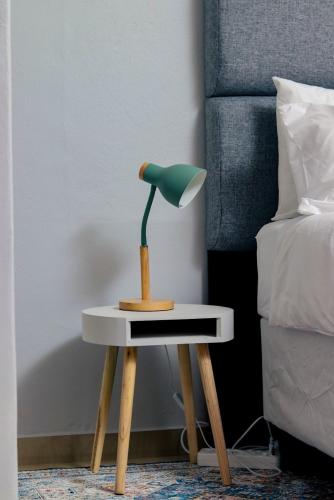 a lamp on a table next to a bed at 19 at Sandla in Mbabane
