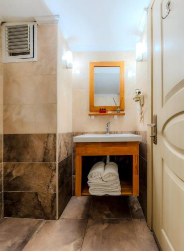 a bathroom with a sink and a mirror and a shower at Hamit Hotel Istanbul in Istanbul