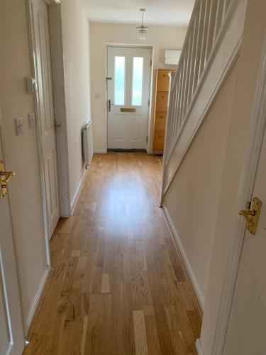 an empty hallway with wooden floors and a door at Oxford four-Bedrooms detached house with driveway parking in Oxford