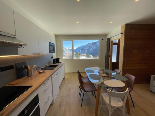 une cuisine avec une table et une salle à manger avec vue dans l'établissement Les Sorbiers Appartements, à Montricher-Albanne