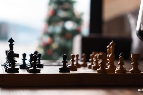 a chess board with chess pieces on a table with a christmas tree at Golden Valley Brezna in Pluzine