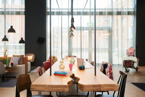 a room with a wooden table with chairs and windows at Moxy Chester in Chester
