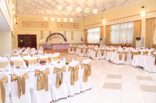 a banquet hall with white tables and chairs at Ust-Kamenogorsk Hotel in Ustʼ-Kamenogorsk
