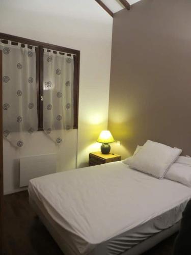 - une chambre avec un lit blanc et une lampe sur une table dans l'établissement Appartement 4 personnes en propriété privée, à Sillans
