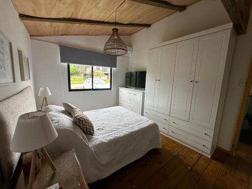 a bedroom with a white bed and a window at Villa Victoria in Manantiales