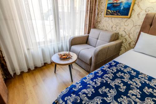 a bedroom with a bed and a chair and a table at Hamit Hotel Istanbul in Istanbul