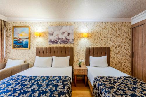a hotel room with two beds and a couch at Hamit Hotel Istanbul in Istanbul