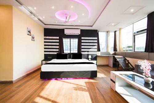 a bedroom with a bed and a desk in it at Super Collection O Hirak Road Dhanbad formerly Hirak Inn in Dhanbād