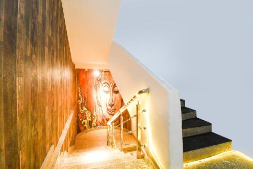 a staircase with a painting of a face on the wall at Super Collection O Hirak Road Dhanbad formerly Hirak Inn in Dhanbād