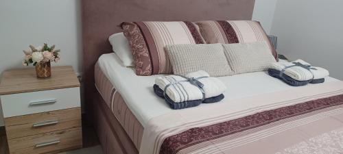 a bedroom with a bed with pillows and a night stand at Apartman Matea - Self Check-in in Osijek