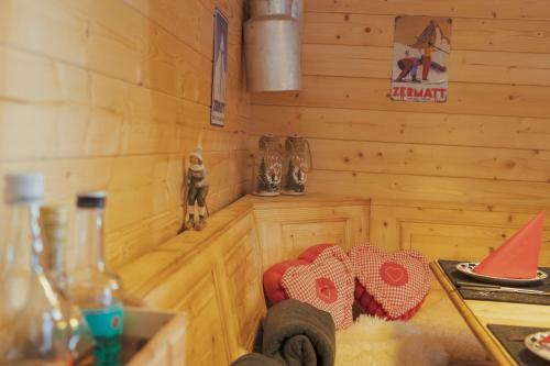 a kitchen with wooden walls and a stove and a counter top at Hotel Jägerhof in Zermatt