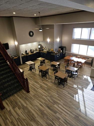 an empty cafeteria with tables and chairs and a counter at AmericInn by Wyndham Mounds View Minneapolis in Mounds View