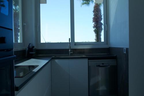 a kitchen with a sink and a window at Luxury villa Lucy with pool on front of beach of Donnalucata in Donnalucata