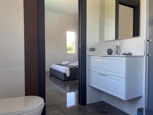 a bathroom with a white sink and a toilet at Luxury villa Lucy with pool on front of beach of Donnalucata in Donnalucata