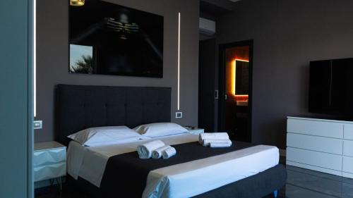 a bedroom with two beds and a flat screen tv at Luxury villa Lucy with pool on front of beach of Donnalucata in Donnalucata