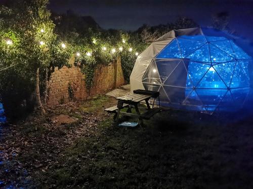 una tenda e un tavolo da picnic in un cortile di notte di Secret Heated Dome, Hot Tub,Firepit Projector in Lincoln a Lincoln
